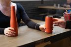 Customer handing a Duet coffee cup to a barista over a counter, while holding the matching water bottle.