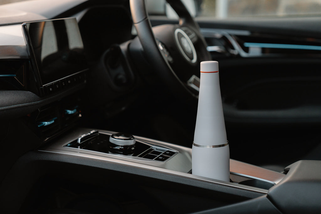 Fully assembled grey Duet coffee cup and water bottle system positioned in a car cup holder.