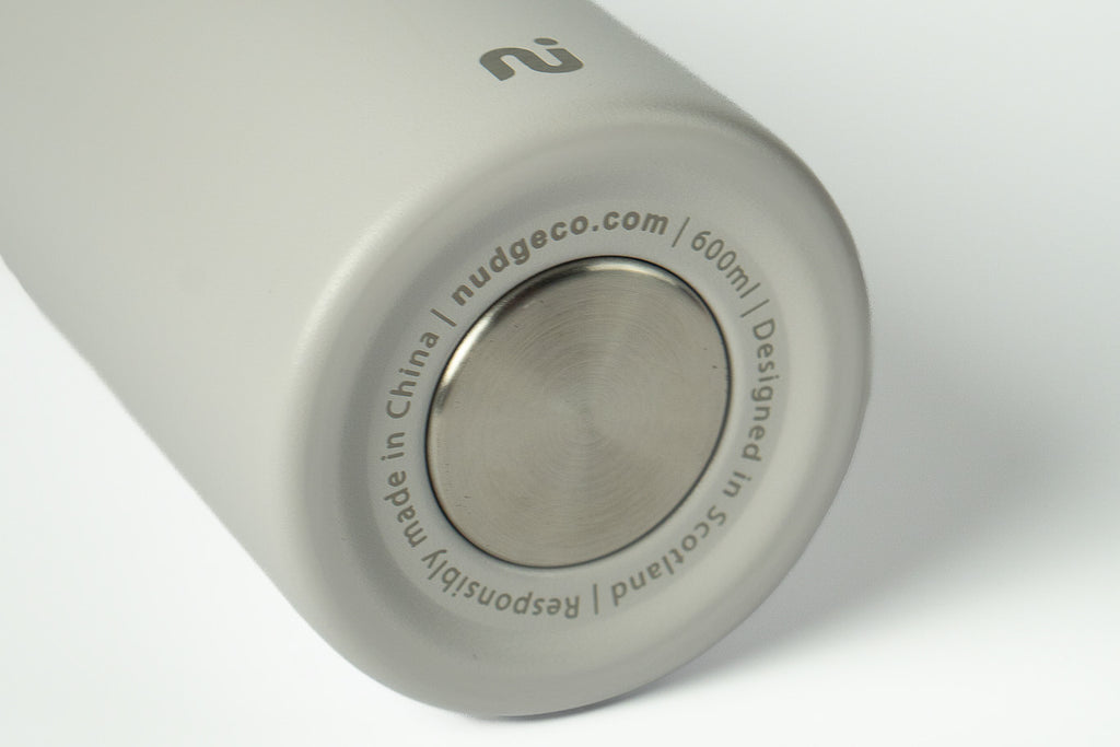 Close-up of a grey Duet water bottle showing branding and capacity markings, on a white background.